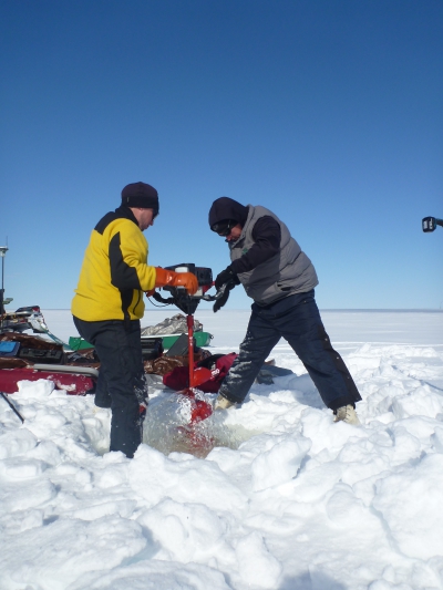 Christopher Arp and Benjamin Jones auguring a hole in the lake ice to install instruments and collect water samples for lab analysis. The instruments measure properties associated with lake ice growth and decay, water temperature, and water chemistry. Photo courtesy of Guido Grosse.