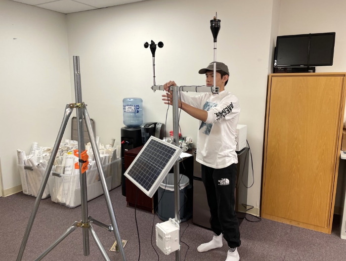 Figure 4. Mikal Nelson erecting an environmental sensor station at the TRIBN office in Utqiaġvik. Photo courtesy of Lars Nelson.