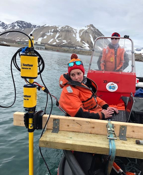 Figure 2. PhD student Kelly Mckeon troubleshooting our bathymetry equipment. Dr. Julie Brigham-Grette is driving the boat. Photo courtesy of Mark Goldner.
