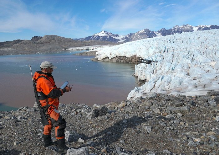 Figure 3. Mark flying the drone above the Kongsbreen Glacier. A sediment plume is visible coming off the glacier. Photo courtesy of Mark Goldner.