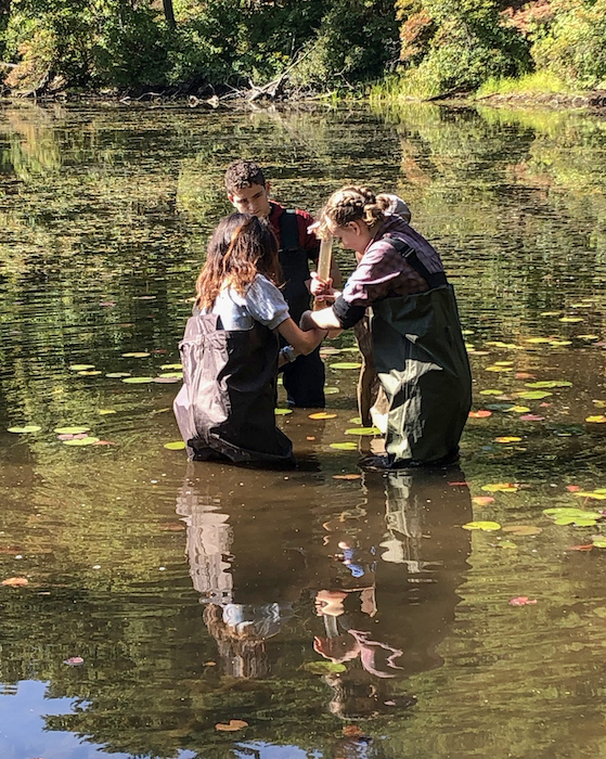 Figure 5.  Mark&#39;s students coring sediment at a local pond. This is one of the ways that Mark has brought his Arctic research into his curriculum, which has increased interest and enthusiasm for science among his students. Photo courtesy of Mark Goldner.