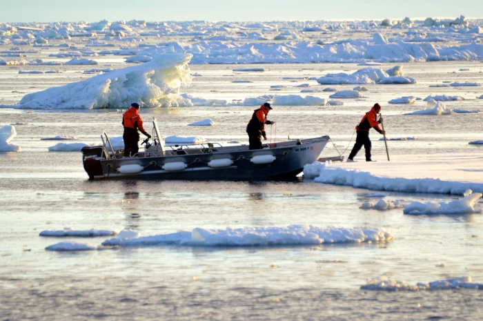 From left to right: Sikuliaq crew members Paul St. Onge (bosun), John Hamill (second mate), and Ethan Roth (marine science technician) test an ice floe for safety. Photo courtesy of  Kimberly Kenny.