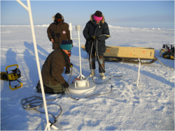 Scientists installing an ice mass balance buoy (IMB)