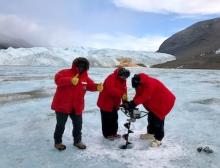 The Microbial Interactions in Antarctic Lakes team use a Jiffy drill to drill into the ice of Lake Bonney, McMurdo Dry Valleys, Antarctica. Photo by Lucy Coleman.