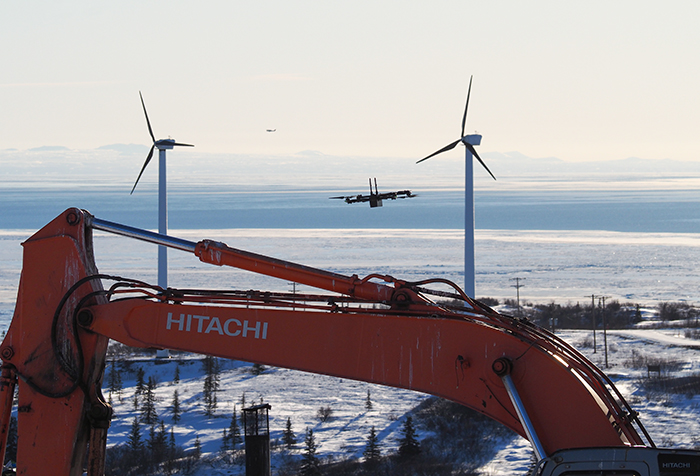 Figure 2. Skydio X2E uncrewed aircraft during 3D scan flight at Unalakleet landfill as piloted by NVU UAS Pilot K. Daniels; Bering Sea in background. Photo courtesy of Mike DeLue.