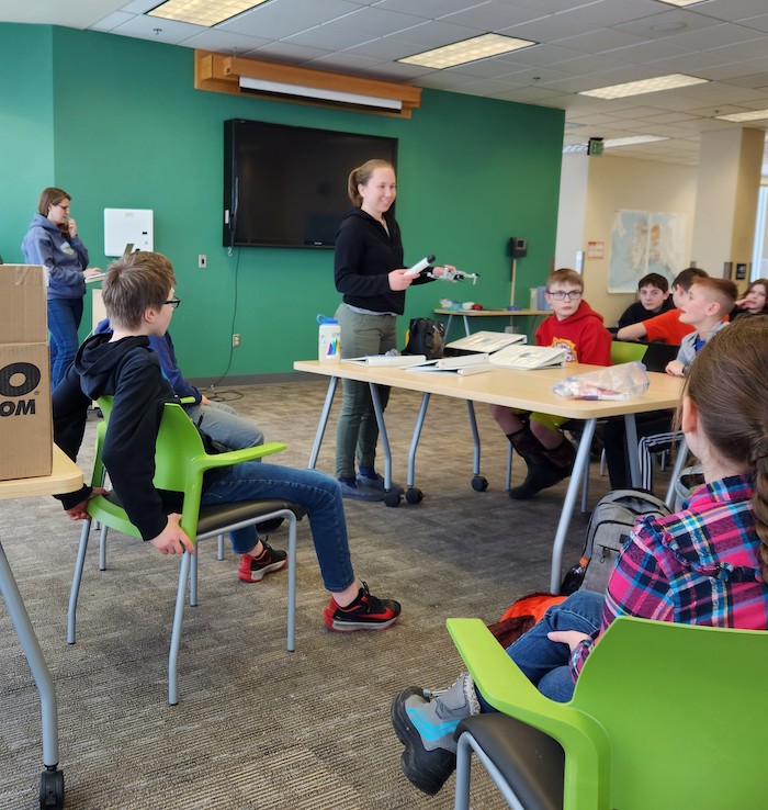 Figure 3.Team members Emily Eidam (left) and Sarah Clement (center) help students from Fairbanks CyberLYNX start thinking about how to measure river sediment with optical backscatter sensor (OBS) sensors and drones. Photo courtesy of Chris Arp.