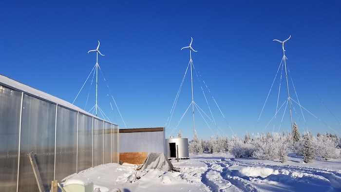 Figure 2: Wind turbines near a greenhouse in Igiugig, Alaska in January 2020.  These turbines are mobile enough to fit on airplanes that service rural Alaska and provide energy for the community. Photo courtesy of Jennifer Schmidt.